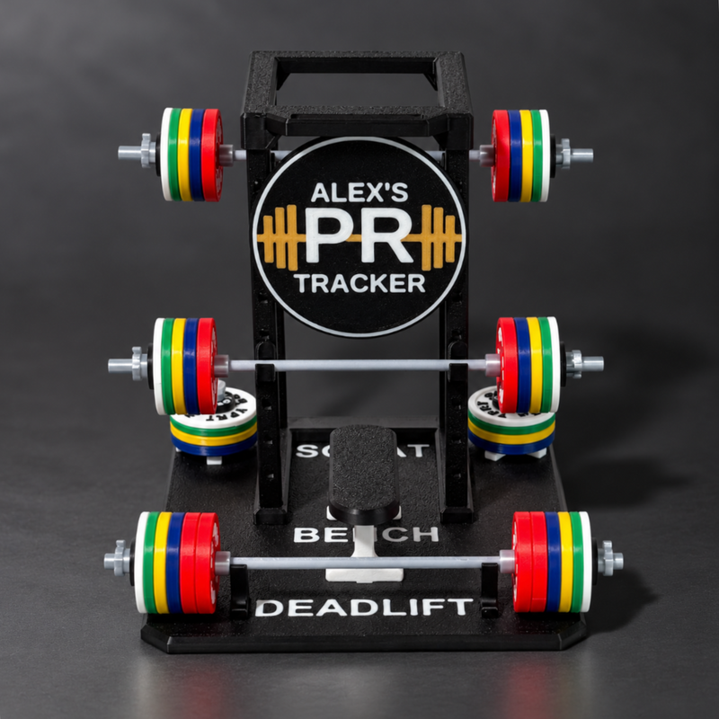 A black bench press display stand labeled 'ALEX'S PR TRACKER' with three horizontal bars holding colorful weight plates in red, yellow, green, and white, photographed on a dark gray studio background.